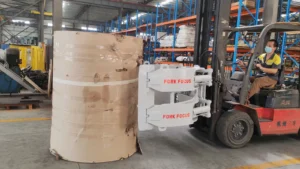 ForkFocus paper roll clamp approaching a large paper roll in a warehouse