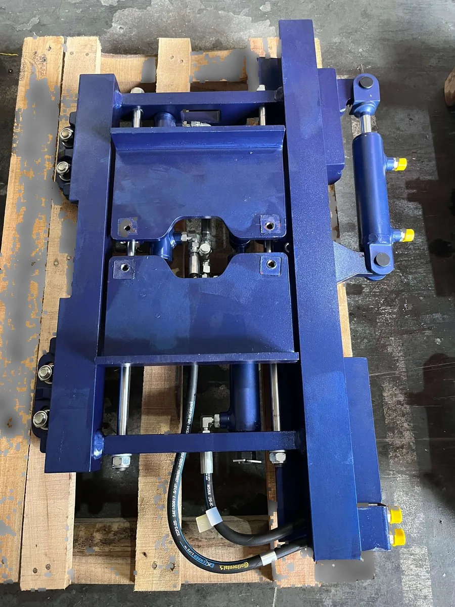 Fork positioner attachment showing hydraulic cylinders, mounting structure and hoses