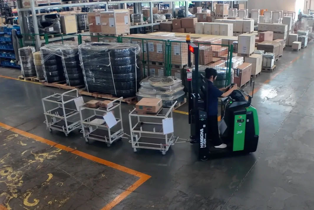Hangcha electric tow tractor pulling three connected industrial trailers in a warehouse