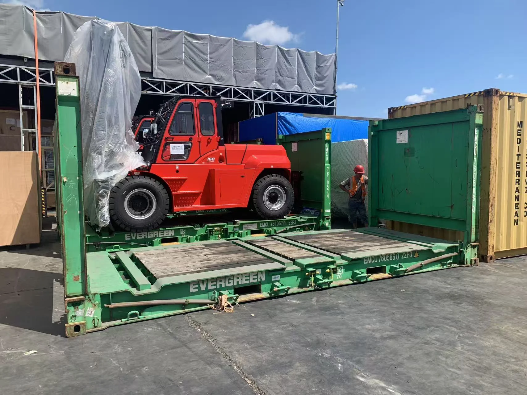 Heavy forklift positioned on a 20-foot flat rack