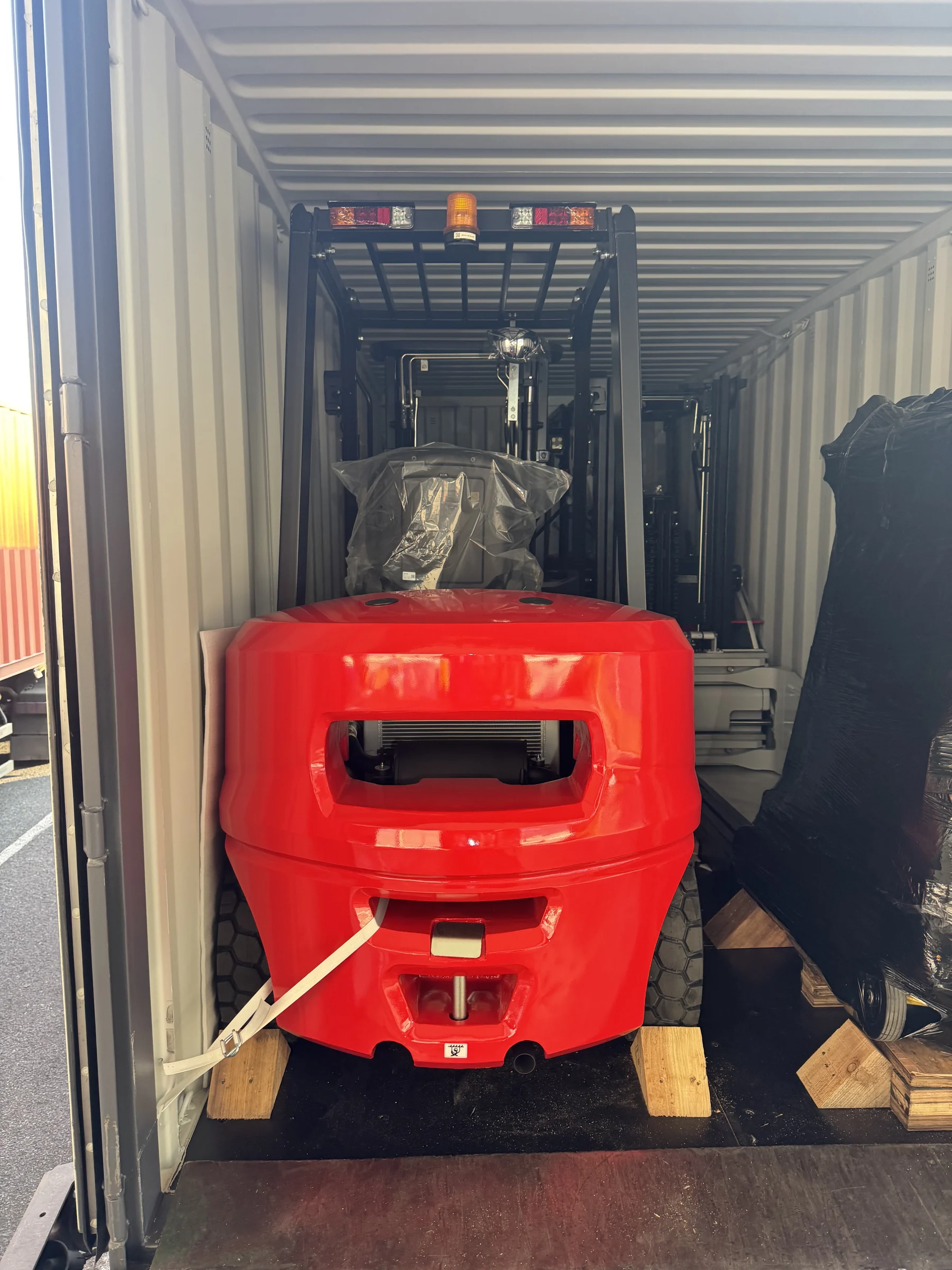 Rear view of a forklift positioned and secured inside a 20GP container