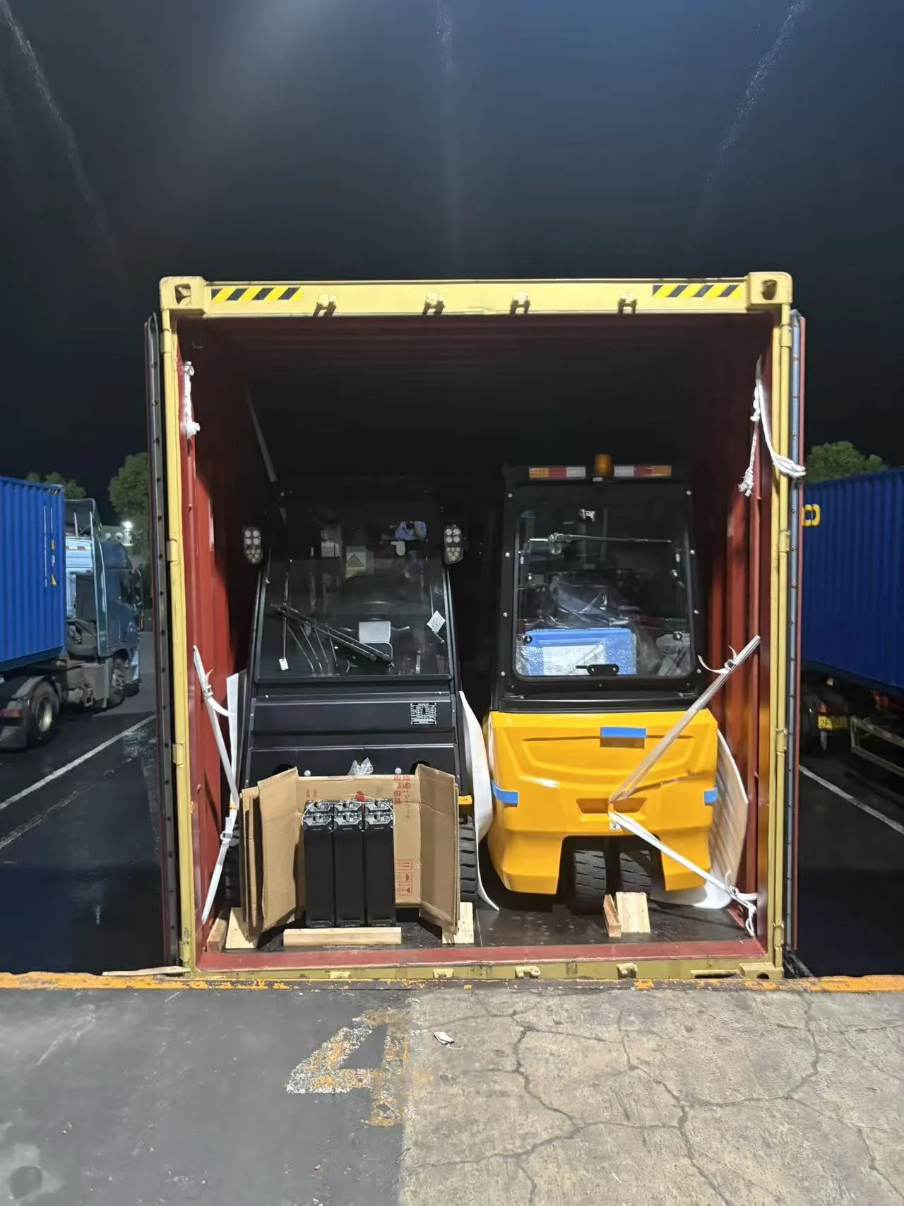 Forklifts and packed items at the open end of a 40HC container