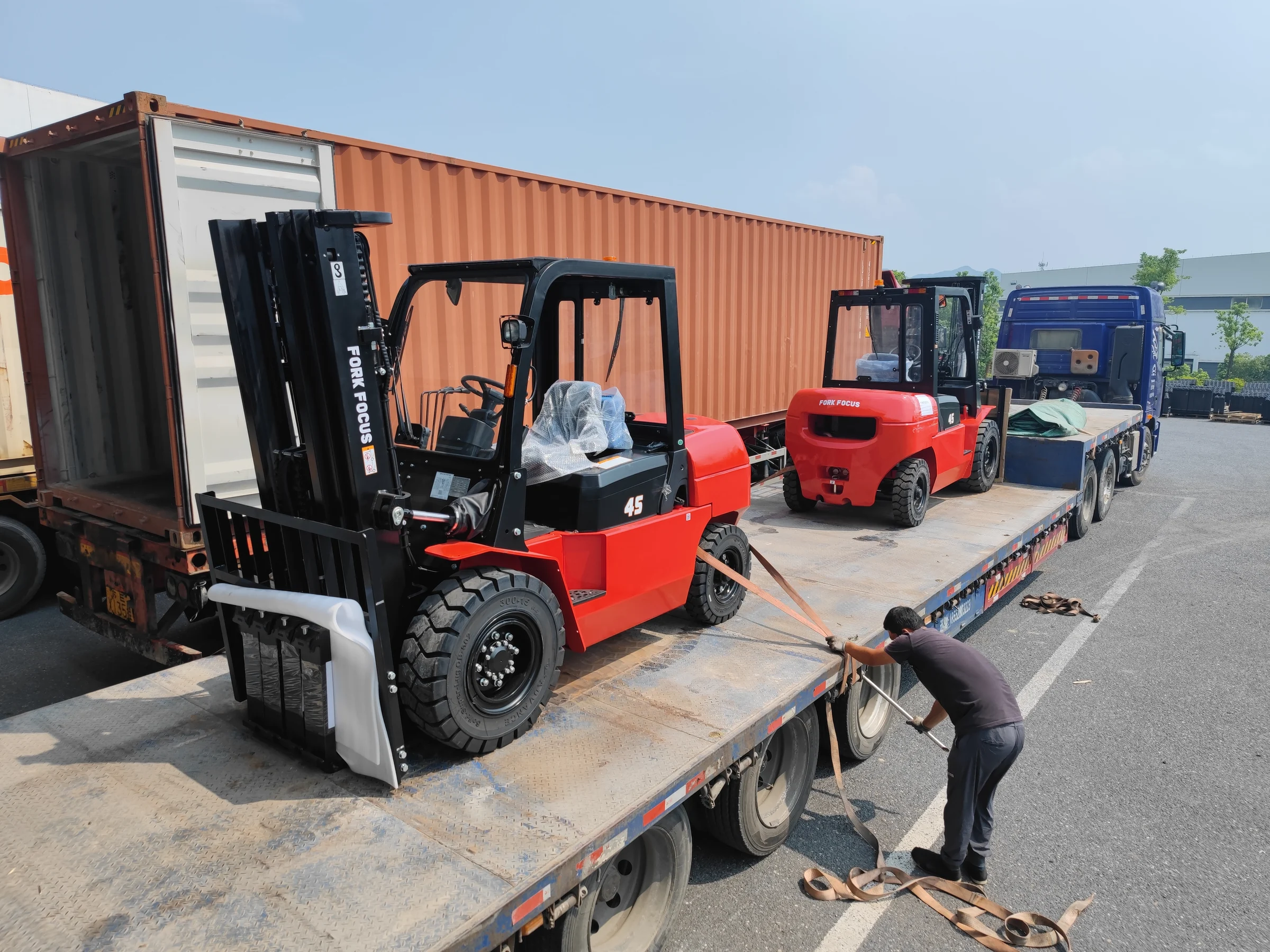 Forklifts being loaded onto a road trailer for dispatch